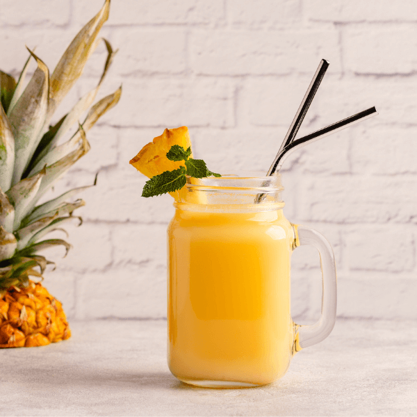 Tropical pineapple smoothie in a mason jar, selective focus.