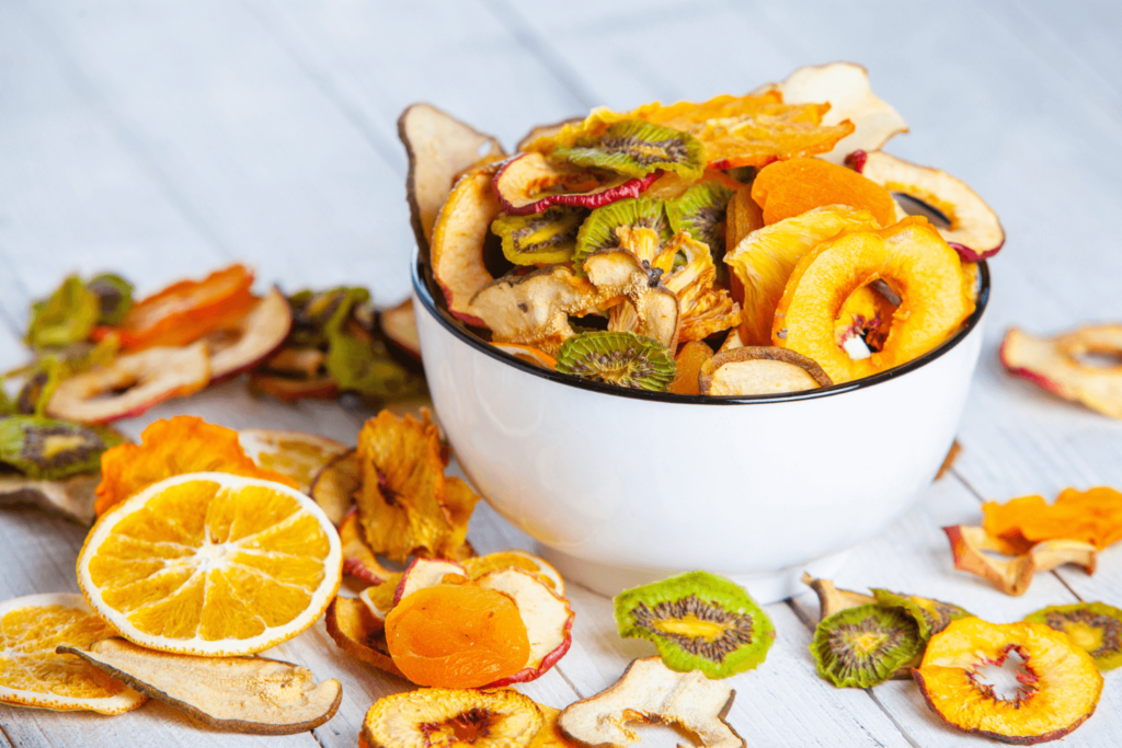 Bowl of dried fruit including oranges, kiwi, apricots, apples, and peaches.