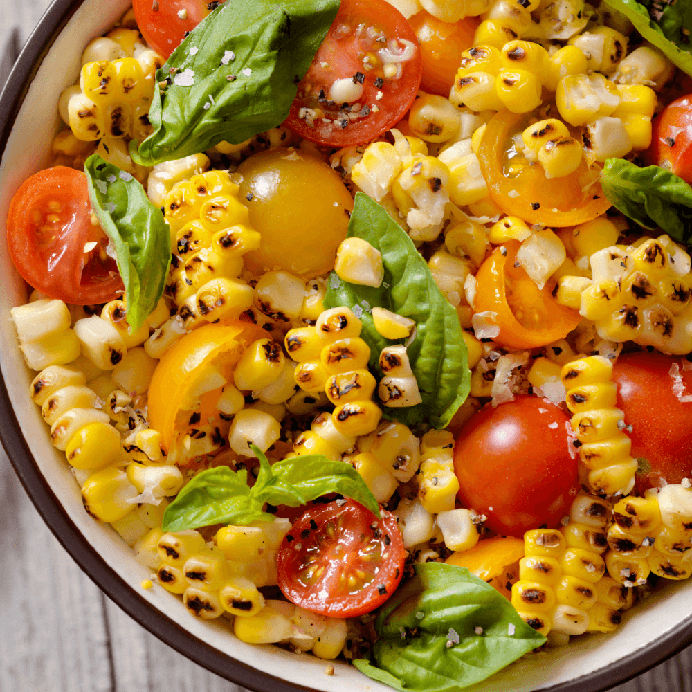 Grilled corn salad with multi-coloured cherry tomatoes and fresh basil.