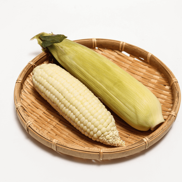 cobs of white flour corn on bamboo plate