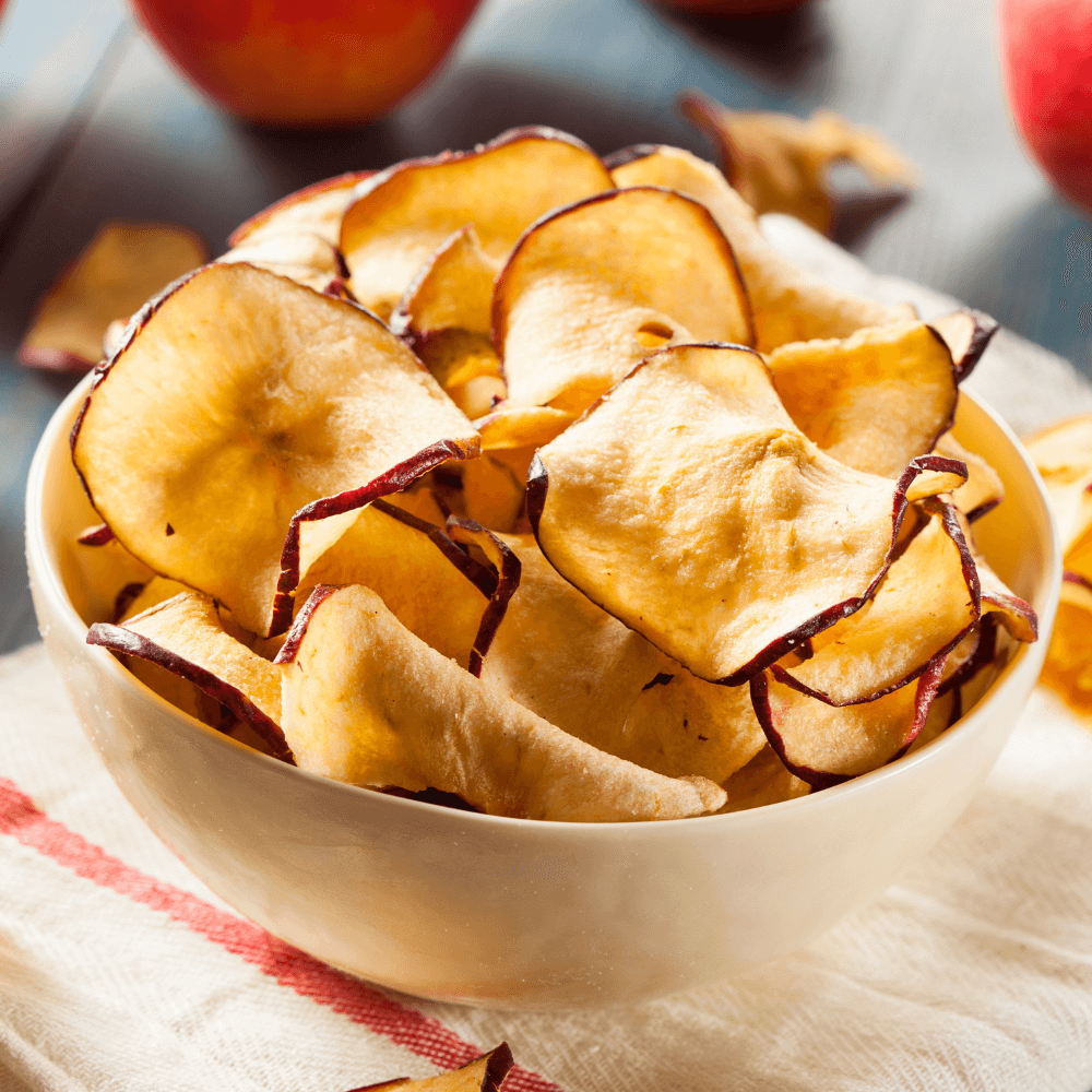 White bowl of dried apple chips.