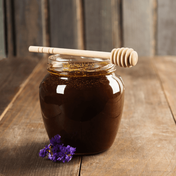 Buckwheat honey over brown wooden background