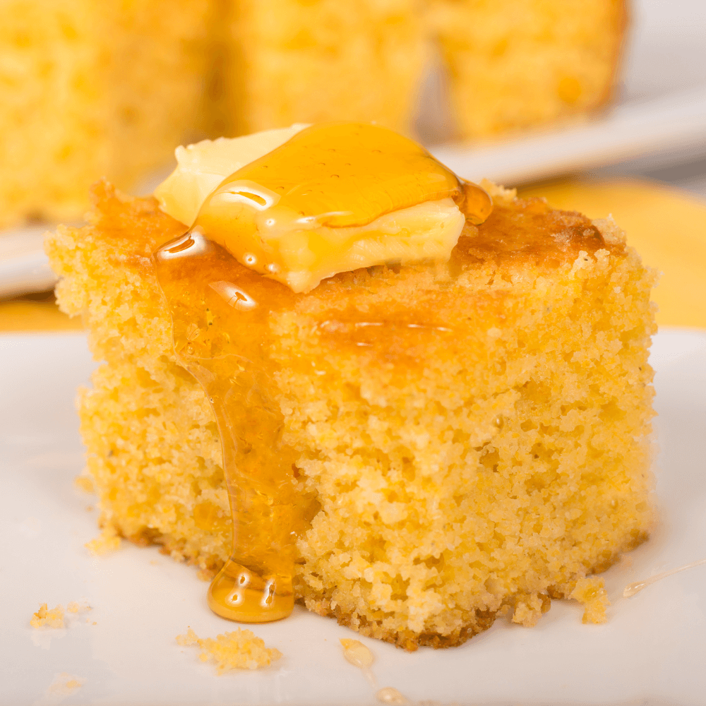 sliced of cornbread with pate of butter and drizzle of honey.