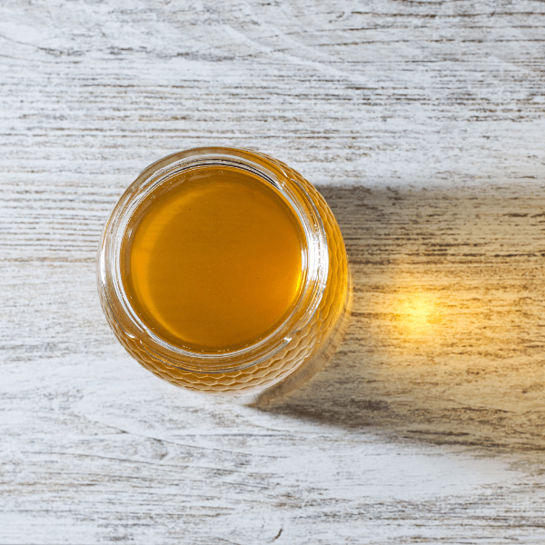 Orange blossom honey, zenith photo, showing the orange color reflected in the wood.