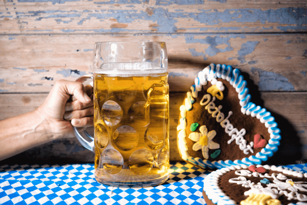 hand with beer on wooden background with gingerbread hearts