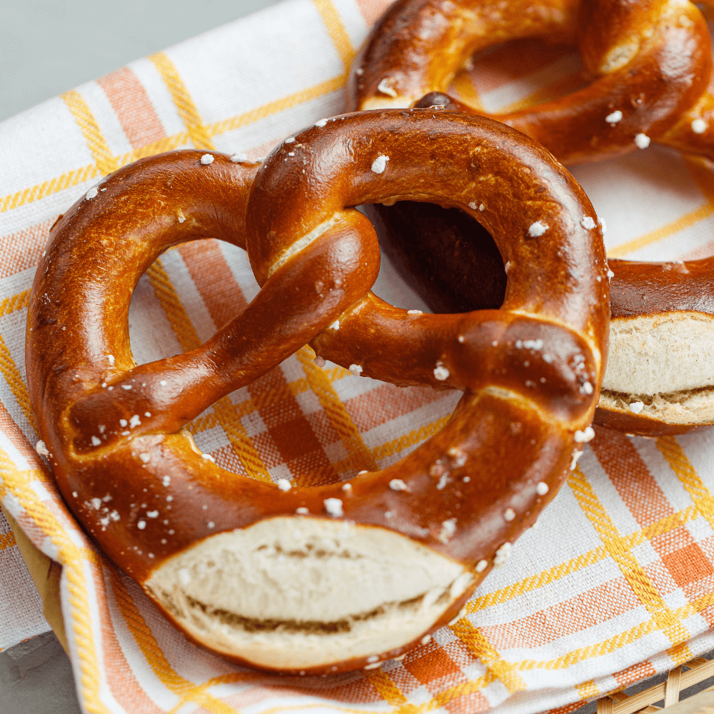 Large Oktoberfest pretzels on yellow and orange plaid cloth.