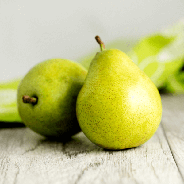 Two Anjou pears sitting on a white wooden table