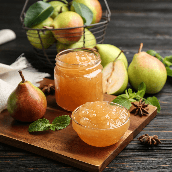 Delicious pear jam and fresh fruits on black wooden table.